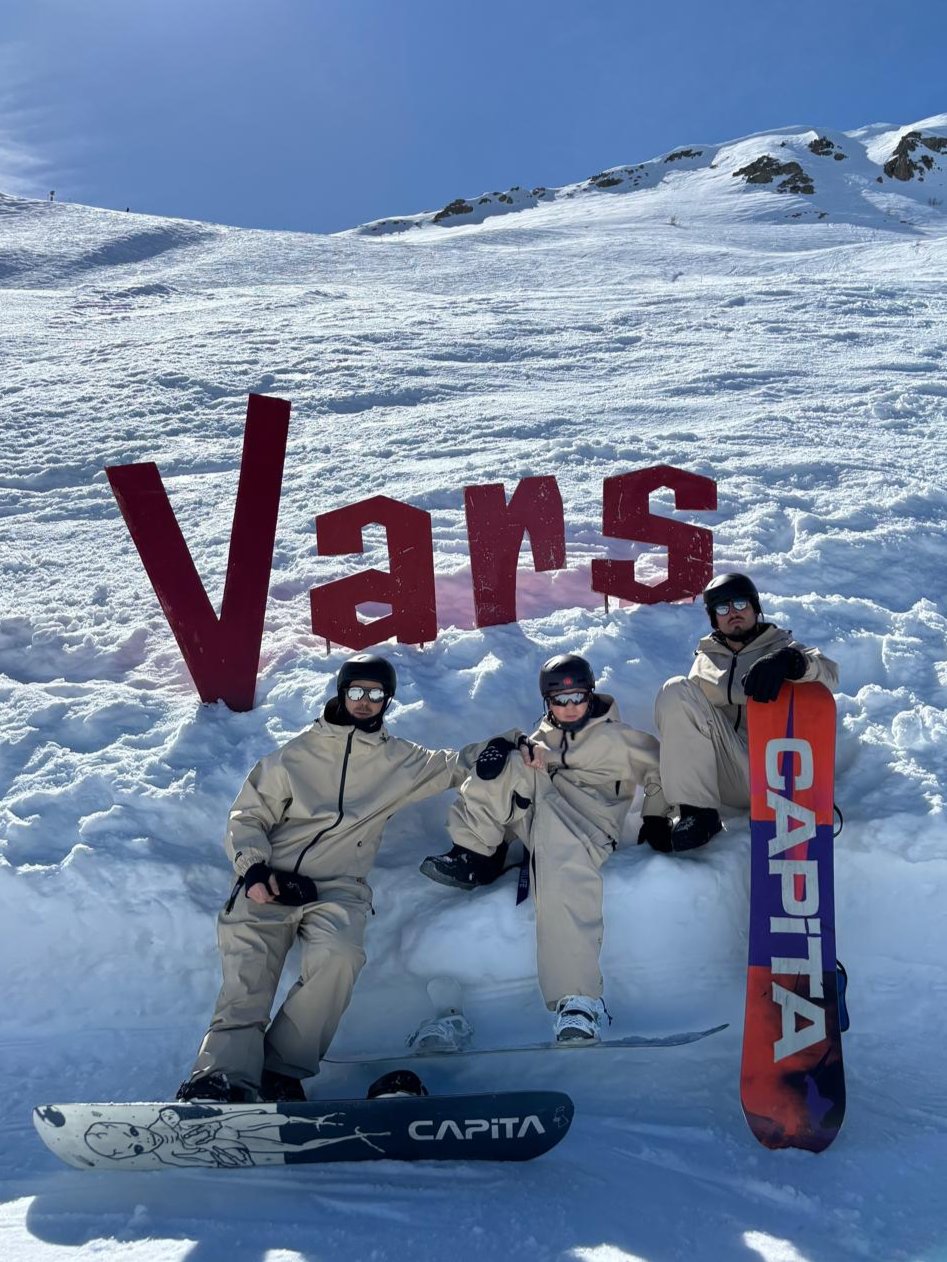 Grupo de snowboarders posando en la nieve con sus tablas